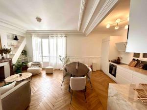 eine Küche und ein Wohnzimmer mit einem Tisch und Stühlen in der Unterkunft Blanche house près du Moulin rouge in Paris