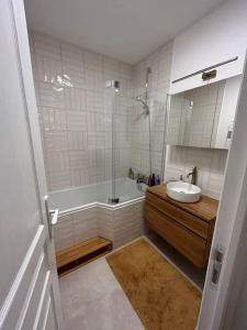 ein Bad mit einer Badewanne, einem Waschbecken und einer Dusche in der Unterkunft Blanche house près du Moulin rouge in Paris