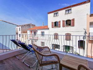 un balcone con sedie, tavolo e un edificio di Layla Luxury Home a Santa Teresa di Gallura