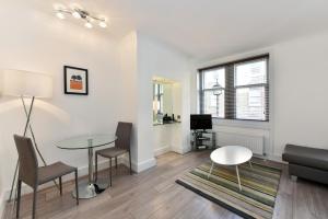 a living room with a table and chairs and a couch at Chiltern Street Serviced Apartments by Globe Apartments in London