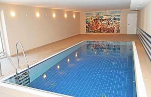 - une piscine dans une pièce ornée d'une peinture murale dans l'établissement Haus Meeresblick - Ferienwohnung Strandmuschel, à Baabe