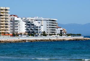 レスカラにあるApartamentos Passeig Del Marの建物と海を望むビーチの景色を望めます。