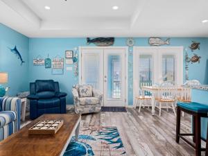 sala de estar con paredes azules, mesa y sillas en Turtles Nest, en Rockport