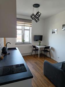 een keuken en een woonkamer met een tafel en een bank bij Blues Rooms in Gdynia