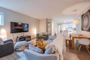 a living room with a couch and a dining room at Evergreen Condo by Leavetown Vacations in Penticton