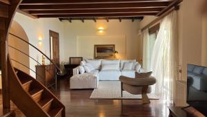 een slaapkamer met een wit bed en een stoel bij Carmel Villas in Drymon