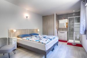1 dormitorio con 1 cama grande y 1 silla en Villa Cutalello coté montagne Calenzana, en Calenzana