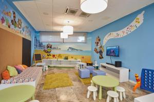 a childrens room with a table and a couch at Sandos Benidorm Suites in Benidorm