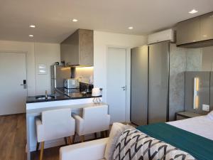 サンパウロにあるJockey Club Residenceのベッドルーム1室(ベッド1台付)、キッチン(カウンター付)