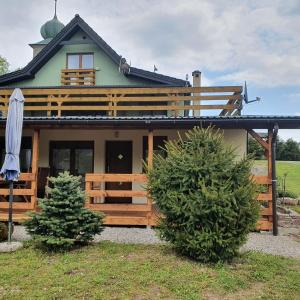 uma casa com dois pinheiros em frente em Domek Dzika Orlica em Mostowice