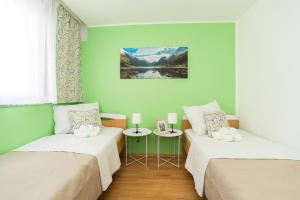 2 łóżka w pokoju z zielonymi ścianami w obiekcie Apartment Mihaela w mieście Zadar