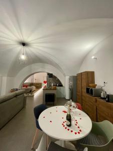 Archome Luxury Apartment في برينديسي: غرفة معيشة مع طاولة بيضاء ومطبخ