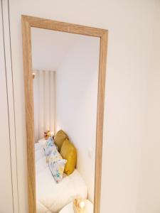 um espelho que reflecte um sofá branco num quarto em RAIO FLAT em Braga