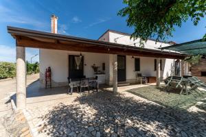 uma casa com um telhado de madeira e um pátio em Angelo's Country House em Bernalda