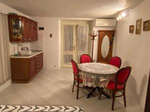 a kitchen with a table and red chairs in a room at 'Round the Corner in Piran +9 photos