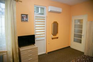 a bedroom with a tv on a dresser and a mirror at Guest House Dobrudzha in Gabrovo
