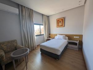 um quarto de hotel com uma cama e um sofá em Sahara Line Hotel em Laayoune