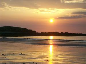 una puesta de sol en una playa con puesta de sol en Like walking into a fantastic novel at Inishowen House, en Rashenny