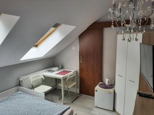 a attic room with a desk and a bed at Pokoje gościnne OSKAR in Łeba