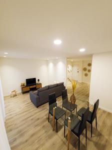 uma sala de estar com um sofá, uma mesa e cadeiras em RAIO FLAT em Braga