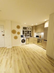 a large kitchen with wooden floors and appliances at RAIO FLAT in Braga