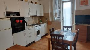 a kitchen with a table and a kitchen with a stove and a washing machine at Casa Sofia in Novi Ligure