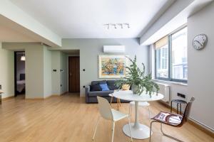 Bright 2BDR Apartment Downtown Exarcheia! في أثينا: غرفة معيشة مع طاولة وأريكة