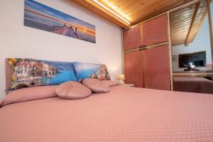 a bedroom with a large pink bed with pink pillows at Casa Rosamare, 150 stairs from the road by Wonder Tour in Praiano +14 photos