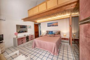 a bedroom with a bed and a tv in it at Casa Rosamare, 150 stairs from the road by Wonder Tour in Praiano