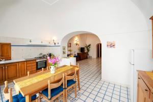 a kitchen and dining room with a table and chairs at Casa Rosamare, 150 stairs from the road by Wonder Tour in Praiano