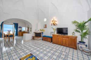 a living room with a tv and a table at Casa Rosamare, 150 stairs from the road by Wonder Tour in Praiano
