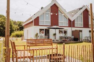 una casa con un banco y una sombrilla en el patio en Das Seehaus en Nordhorn