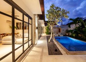 a villa with a swimming pool and a bedroom at Billi Bali Villa in Canggu