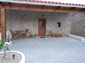 a patio with a wooden door and a table and chairs at Casa da Rabita in Capinha