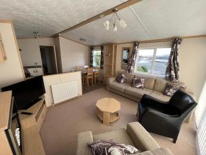 ein Wohnzimmer mit einem Sofa und einem Tisch in der Unterkunft Cascade Lodge & Hot Tub in Donegal