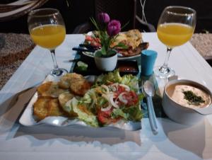 a table with a plate of food and two glasses of orange juice at HOTEL HERMOSO CARIBE in Tolú +20 photos