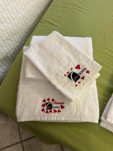 dwa białe ręczniki siedzące na zielonym łóżku w obiekcie Archome Luxury Apartment w mieście Brindisi