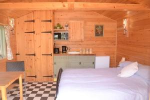 a bedroom with a bed in a wooden cabin at Woolcombe Cabin in East Allington