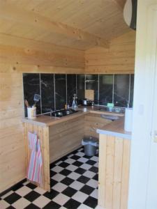 a kitchen with a black and white checkered floor at Woolcombe Cabin in East Allington