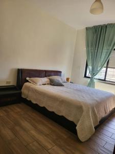 a bedroom with a large bed with a window at Superb 2 Bed in middle of Amman in Amman