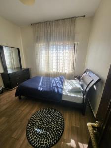 a bedroom with a bed and a window and a rug at Superb 2 Bed in middle of Amman in Amman