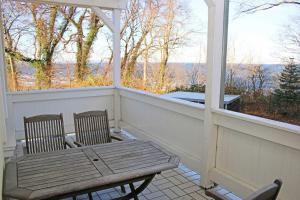 a porch with two chairs and a bench on it at Villa Strandmuschel - FeWo 05 in Göhren