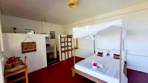 a bedroom with a bed with a canopy at Villa c'est la vie in Nosy Komba