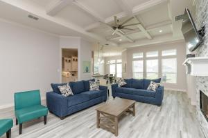a living room with two blue couches and a fireplace at Luxurious 4-Bedroom Retreat Near the Beach: King Suite, High-Speed WiFi, Free Parking in Corpus Christi