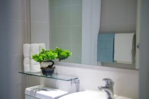 a bathroom with a sink and a mirror and a toilet at O&O Group- 1BR Azure Resort Pool Beach Netflix in Manila
