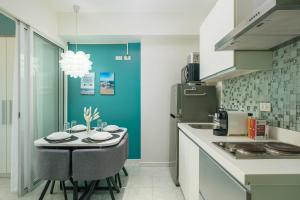 a kitchen with a table with chairs and a refrigerator at O&O Group- 1BR Azure Resort Pool Beach Netflix in Manila