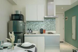 a kitchen with white cabinets and a green refrigerator at O&O Group- 1BR Azure Resort Pool Beach Netflix in Manila