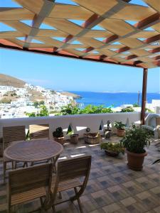 a patio with a table and chairs and a view of the ocean at Primrose Apartments in Astypalaia Town