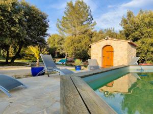 a swimming pool with two chairs and a house at OFILDLEAU in Sillans-la Cascade