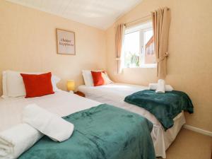 two beds in a small room with a window at Mojo in Ilfracombe